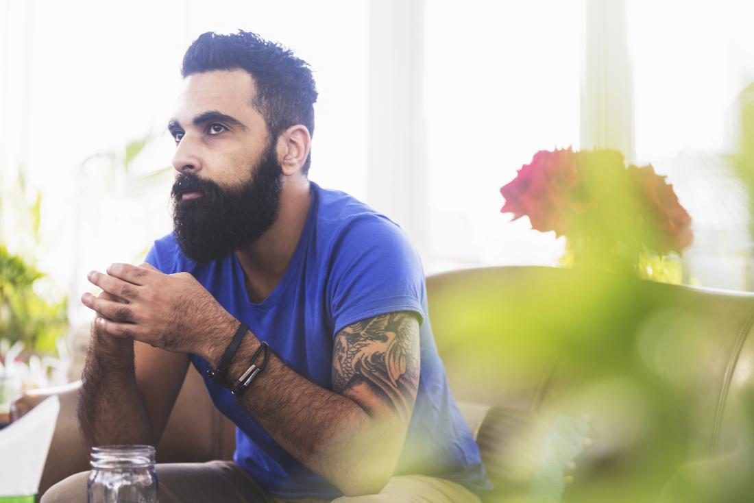 Thoughtful man with tattoos thinking about average penis size